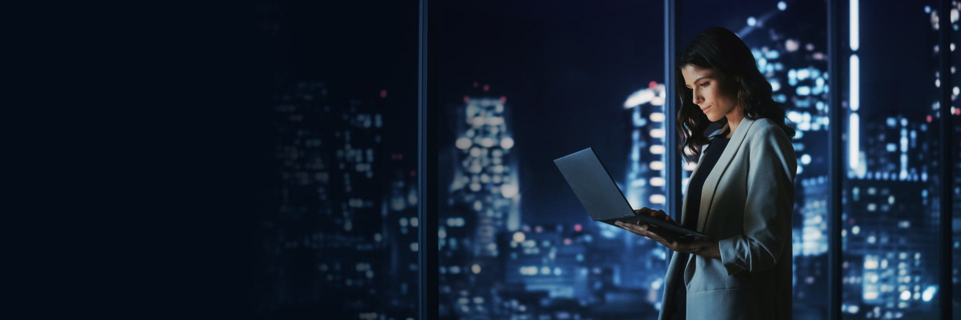 Professional using a laptop at night, highlighting StoneX Wealth Management's advanced wealth management platform for global access
