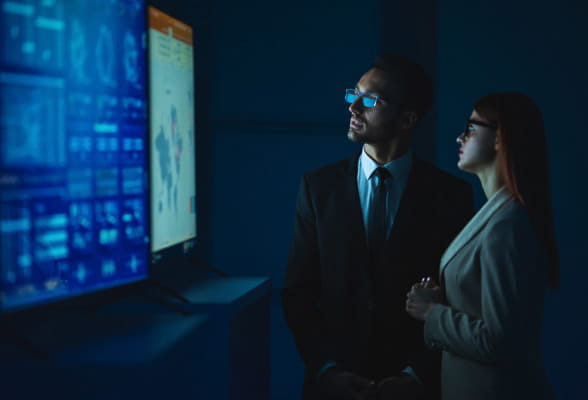 Two professionals analyzing data on screens, representing StoneX Pro's liquidity expertise and efficient onboarding for hedge funds.